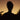Silhouette of a person with dreadlocks against a sunset sky