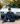 Person sitting in front of a classic car on a street