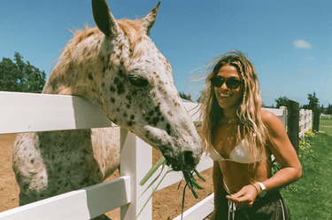 Coco taking time to feed her horse on a beautiful sunny day