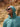 Man wearing a teal hoodie with a hood, sunglasses, and a Patagonia logo in a desert setting.