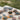 Collection of sunglasses on a stone surface with a blurred natural background