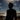 Silhouette of a person on a beach with ocean waves and sky.