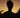 Silhouette of a person with dreadlocks against a sunset sky