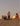 Friends sitting by a bonfire on the beach at sunset