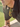 Person wearing green sunglasses on a blurred outdoor background