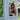 Woman in a black bikini holding a glass on a balcony with greenery