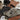 Collection of clothing and accessories including a jacket, pants, shoes, hats, and sunglasses on a neutral background.