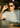 Man adjusting sunglasses with a blurred indoor background